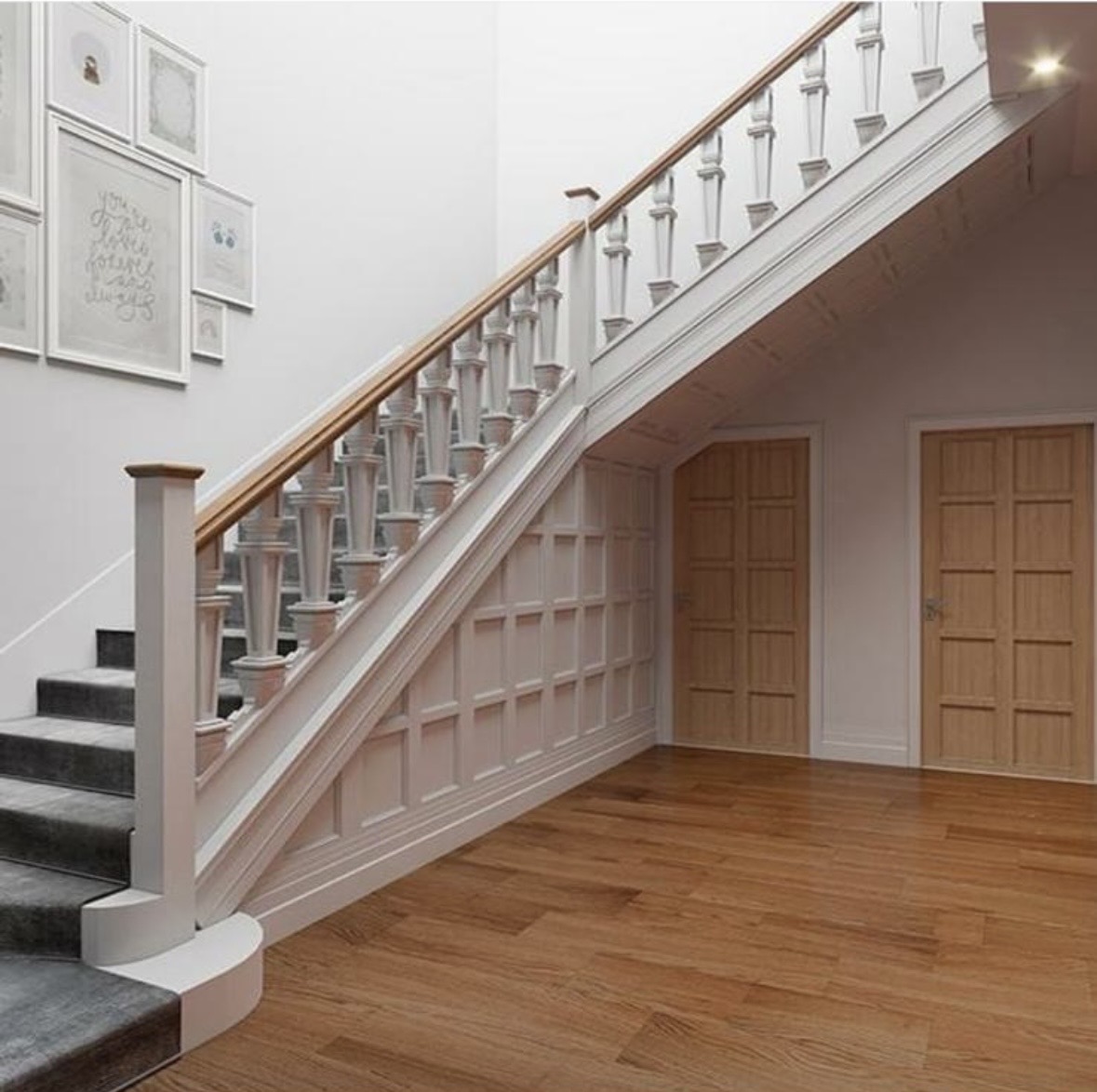 Finished apartment hallway with oak flooring, panelled staircase and white spindles