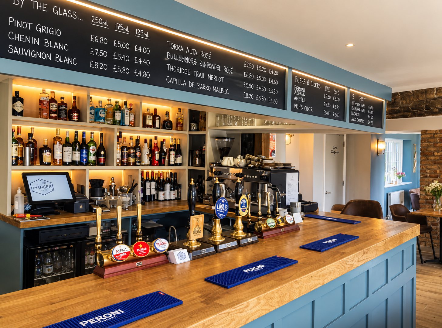 Finished commercial bar with bespoke timber counter, illuminated shelving and painted joinery