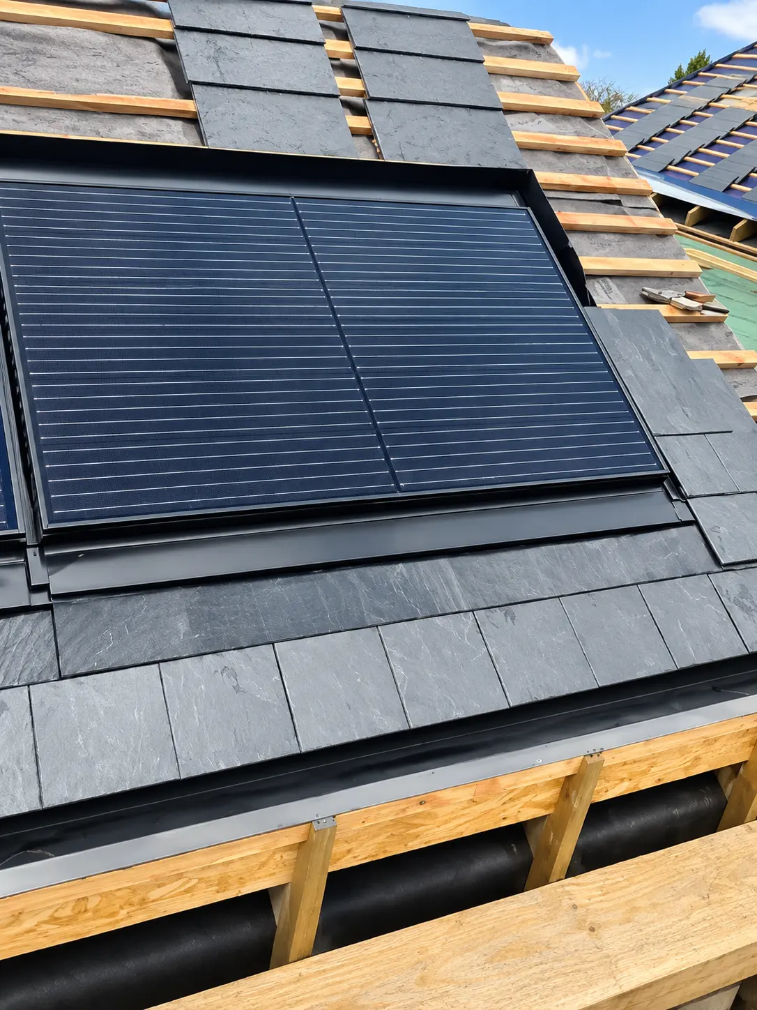 Solar panel integrated into a new slate roof during construction